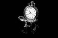 Monochrome image, silver pocket watch on dark shiny surface Royalty Free Stock Photo