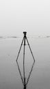 A monochrome image of a tripod upright on a beach Royalty Free Stock Photo