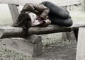 Monochrome image of a woman on a park bench