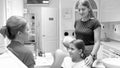 Black and white image of young mother and her teenage daughter visiting dentist Royalty Free Stock Photo