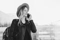 Monochrome image. Young tourist woman in hat and with backpack is standing at airport and talking on cell phone. Royalty Free Stock Photo