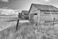 Monochrome landscape of old farm buildings with a sun burst above Royalty Free Stock Photo