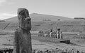 Monochrome Moai A Vere Ki Haho with the 15 Moai statues of Ahu Tongariki ceremonial platform in background, Easter island, Chile Royalty Free Stock Photo