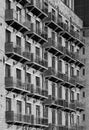 Monochrome perspective view of the facade of a large old stone mill building converted into apartments with modern glass