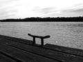 Monochrome perspective of wooden deck along a river shore with steel clit