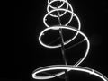 Monochrome photo. Christmas installation. spiral of light, black night sky.
