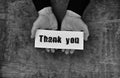 Monochrome photo male hands holding a white blank thank you on s
