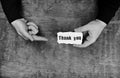 Monochrome photo male hands holding a white blank thank you on s