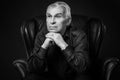 Monochrome portrait of elderly thoughtful man in studio