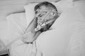 Monochrome portrait of Sleeping man with chronic breathing issues considers using CPAP machine in bed. Royalty Free Stock Photo