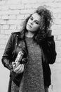 Monochrome portrait of young beautiful cheerful woman with curly hair on white bricks wall background. Royalty Free Stock Photo