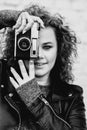 Monochrome portrait of young beautiful cheerful woman with curly hair on white bricks wall background. Royalty Free Stock Photo