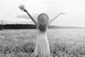 monochrome portrait of young girl in a hat standing in a huge fi Royalty Free Stock Photo