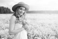 monochrome portrait of young girl in a hat standing in a huge fi