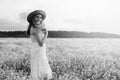 monochrome portrait of young girl in a hat standing in a huge fi Royalty Free Stock Photo