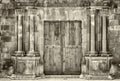 Monochrome sepia ancient wooden double doors in an old stone building with crumbling ornate columns surrounding the entrance Royalty Free Stock Photo
