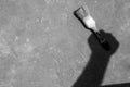 Shadow of a hand is holding a spatula on a concrete background