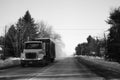 Monochrome shot of the truck driving on an empty winter road