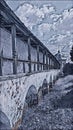 Monochrome sketch photographic art picture of orthodox monastery and rusty roof of its surrounding wall under blue cloudy sky in