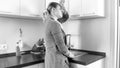 Black and white tired woman washing dishes on kitchen Royalty Free Stock Photo