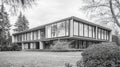 Monochrome view of a functionalist villa showcasing large windows and asymmetric design in a serene landscape Royalty Free Stock Photo