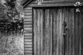 Monochrome view of a wooden, locked garden shed. Royalty Free Stock Photo