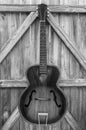 Monochrome Vintage Acoustic Guitar On Fence