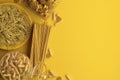 Monochrome yellow composition of dry and boiled pasta and spaghetti on a yellow background. Banner with copy space for text. A set Royalty Free Stock Photo