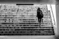 Monochromic shot of a girl climbing the stairs