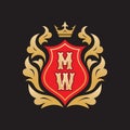 Monogram MW letters - concept logo template design. Crest heraldic luxury emblem. Red shield, golden leaves and crown. Royalty Free Stock Photo