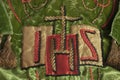 Monogram or symbol for Jesus with a gold cross at top embroidered on Christian vestment.