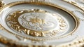 A monogrammed ceramic plate layered with gold and silver accents achieved through the gilding technique.