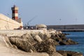 Man fishing in front of lighthouse in Monopoli, Italy