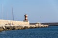 Man fishing in front of lighthouse in Monopoli, Italy