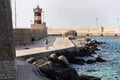 Man fishing in front of lighthouse in Monopoli, Italy
