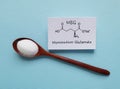 Monosodium glutamate (MSG) chemical formula with spoonful of white glutamate powder. Sodium salt of glutamic acid Royalty Free Stock Photo