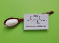 Monosodium glutamate (MSG) chemical formula with spoonful of white glutamate powder. Sodium salt of glutamic acid Royalty Free Stock Photo