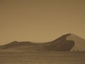 Monotone photograph of beautiful natural sand dune curved ridge with soft shadow on vast empty dried desert landscape Royalty Free Stock Photo