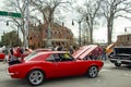 Visitors gather near a bright red vintage automobile at a classic car show in Monroe, Georgia. Royalty Free Stock Photo