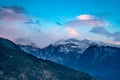 monsoon clouds moving over snow covered himalaya mountains with the blue orange sunset sunrise light over kullu manali Royalty Free Stock Photo