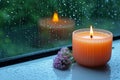 Monsoon serenity flame burning aroma candle by rain streaked window