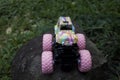 Monster car toys standing on stone and grass