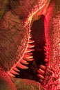 Monster. Close-up of dinosaur creature teeth under evil red light.