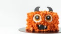 Monster theme cake on the white background. Halloween cake with orange fluffy cream cheese frosting