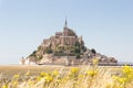 Mont Saint Michel in dry fields with yellow grass at low tide on