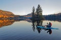 Tourist sitting on a paddleboard taking pictures of beautiful landscape