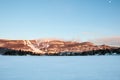 Winter landscape of Ski Resort with Frozen Lake, Ski Slopes, Blue Sky and Moon - Mont-Tremblant, Quebec, Canada