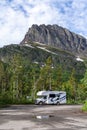 An RV parked at a trailhead parking lot in Glacier National Park