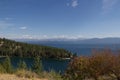 Montana Vista with mountains, water and pines on an outcropping.