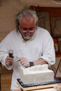 MONTBLANCH, SPAIN - 28 APRIL 2018: Old man making a Marble sculpture in a traditional way at the Montblanc Medieval Week festivity